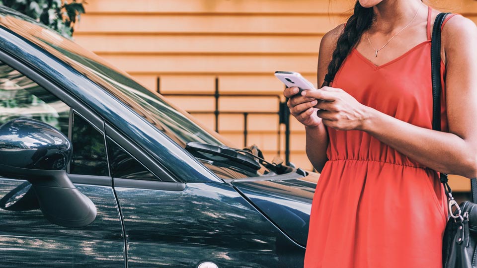 Woman unlocking a car with a phone